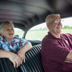 senior couple driving in big car