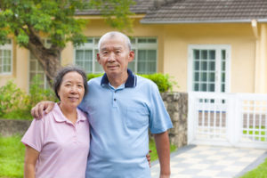 How to Use Your Home to Stay at Home happy asian senior couple standing in front of a house