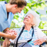 Nurse holding hand of senior woman
