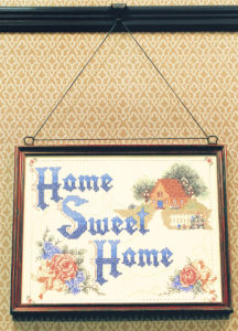 home sweet home needlepoint hanging on wall