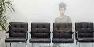 Female caregiver is semi-invisible behind chairs