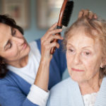 caregiver combing senior patient's hair