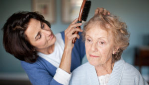 caregiver combing senior patient's hair