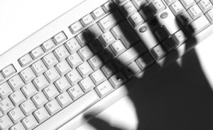threatening hand shadow on keyboard