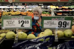 senior woman in mask shopping in grocery store